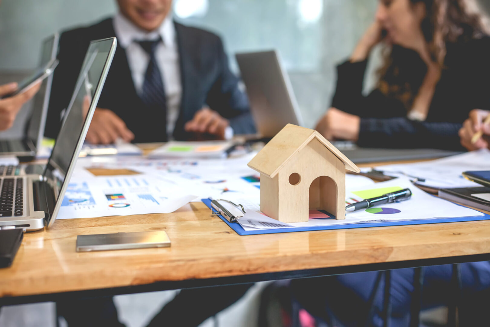 professionals around table with house on table